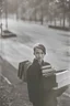 Placeholder: color photo of a student girl 22 years old ,short hair with her books in her hand walking in street,next to trees.