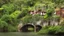 Placeholder: Gigantic mushroom village with balconies, archways, stairs, bridges, bushes, spanish moss, ivy, river, a winding pathway through the middle, in a valley