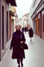 Placeholder: mujeres de 55 años caminando por una céntrica calle de una ciudad española, visten ropa de segunda mano, abrigo y jersey de cuello alto, es la moda y es tendencia, fotografía real, de cara a la cámara