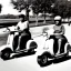 Placeholder: Old photo of people driving a scooter