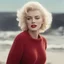 Placeholder: Marilyn monroe, messy hair,, in a large red woollen sweater, on the beach, in the sun