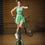 Placeholder: a very beautiful lady with makeup and bub hair, wearing a pretty blue-green sports pants an top, shows her performance driving a Unicycle Wheel Bike