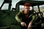 Placeholder: young rough and rugged muscular male photorealistic red hair and green eyes smirking expression sitting in a jeep