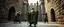 Placeholder: movie poster[Shot 6] An eight-second cinematic fantasy scene in an ancient stone courtyard of a Forgotten Realms castle, late afternoon. Begin with a low wide establishing shot moving slowly forward toward a young wizard in a weathered green cloak and his adventuring companions, a rugged barbarian and cautious ranger. Two goblins approach in the background. The camera gently arcs around the wizard as he raises his staff and confidently begins a summoning spell. poster