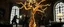 Placeholder: Some well dressed cult figures fighting to contain energy from floating chtonian glowing snakelike tree made by twisted snakelike sticks creating weird geometric form in dramatic scene in luxury parlour in the style of Giger and Escher
