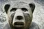 Placeholder: a human with a head of a bear, ancient stone statue, rustic, photograph,