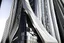 Placeholder: Zaha hadid sheikh chanel, uturistic building facade, located between very tall buildings with mirror facades that reflect it, 16K, ultra realism. day lighting