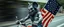 Placeholder: hi speed bad ass cyber punk masculine realistic zombie mickey mouse humanoid with hairy arms and chest, on trike , motion blurred background, holding american flag