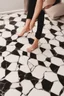 Placeholder: generate a picture of a woman's feet with marble floor as background and white nail polish