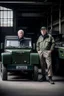 Placeholder: two haggard looking men working in a land rover warehouse