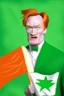 Placeholder: Conan O'Brien with bright orange hair holding orange cheese. "Esperanto flag in background". Green-flag-with-white-star. Green flag in background