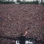 Placeholder: one man on stage in front of massive crowd