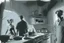 Placeholder: black and white storyboard, couple on foreground, we don t see them well because they are close and between them in the middle we see 3 cooks, scattered throughout the kitchen