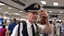 Placeholder: drunk pilot holding bottle of liquor gets confronted by crowd of travelers at airport