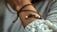 Placeholder: macro photo of a bracelet made of brown leather and tiny pearls in ethno style around a woman's wrist, detailed, sharp contrasts, realistic, cinematic, blur background