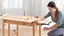 Placeholder: woman assembling the table she just received