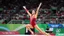 Placeholder: Please provide a detailed Photo of a female gymnast performing her routine on the floor exercise at the Olympic Games. Include specific elements of her performance, such as her choreography, the difficulty of her moves, her artistry, and how she engages the audience. Additionally, describe the atmosphere of the event, the reactions of the crowd, and any notable aspects of her presentation. The output should be structured in a way that captures the excitement and technical skill of the performanc