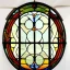 Placeholder: circular wrought iron frame window with stained glass effect, highly detailed, intricate, warm colors, alphonse mucha