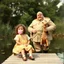 Placeholder: Nostalgic vintage color photograph of a preconscious girl with curly hair blowing a pink bubblegum bubble while sitting on a small dock of a summertime pond, standing behind her is a hugely fat man dressed in a beige US generals uniform with a cornhusk hat, General is holding a giraffe stuffed animal