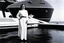 Placeholder: [photo by Helmut Newton] Princess Leia close to her spaceship, she stands on the side of the ship, her feet on the hull