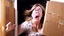 Placeholder: woman starts frantically tearing apart large door sized box scaring her husband