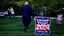 Placeholder: trump 2024 campaign signs all over lawn while manly woman screaming on phone