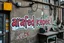 Placeholder: there is an arafed sign that says "arafed képek!" on the wall of a building, rolands zilvinskis 3d render art, dystopian grunge, steampunk grafitti, hyper realistic digital art, sticker art, disco elysium style, pexels, neoexpressionist, gritty background, solarpunk, oilpunk, unsplash transparent, to be or not to be, scrap metal on workbenches, infinite regression, interconnected human lifeforms, by Hans Bol, symbolic mural, a cd album cover art by Kurt Roesch, graffiti, disco elysium character