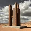 Placeholder: Fotografia di una scultura astratta, composta da elementi verticali e forati che ricordano delle strutture architettoniche. È fatta di un materiale che sembra poroso o corroso, probabilmente metallo o pietra. La scultura è posta su un terreno desertico, con nuvole e cielo plumbeo. L'illuminazione della foto crea forti contrasti di luci e ombre, dando un aspetto drammatico e accentuando la tridimensionalità dell'opera.