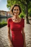 Placeholder: Act like a street photographer. Create a realistic photograph of a small Italian town at Como Lake in late spring with a portrait of a 45-year-old, beautiful, slim Polish woman with small wrinkles and brown hair. Use a 24 mm lens and a Fuji T30 camera for mild light, warm, golden hour photos from a distance, elegant red dress for a dinner, sensual pose