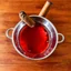 Placeholder: grainy photography, top-down perspective, large punchbowl full of red punch on a wooden table with a chewed brown cigar floating in the bowl, gritty, hyperreal image