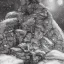 Placeholder: Realistic picture of a norse stone troll in the mountains, reading a book next to a firecamp and under the moonlight, with snow falling in the background and stars in the sky in a nostalgic mood --no dragon --no daylight --no hairs