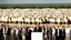 Placeholder: George w bush at podium speaking to large field of sheep