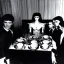 Placeholder: Creepy old photo of giger alien people sitting at dinner with weird children