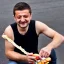 Placeholder: Volodymyr Zelensky WITH A BEARD wearing TANKTOP EATING A HOTDOG