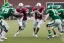 Placeholder: Boston Shamrocks Football team playing against the Toronto Rifles Football team,vintage, hyper-realistic, in color, Boston in green, Toronto in Red