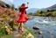 Placeholder: country side over high heels in spring wind slowly moves color full flowers,clean water fall and narrow river with waves and pretty rocks in floor ,some trees and houses ,and mountains at distant,a very beautiful Turkish lady wearing tight pants and blouse salsa dancing , full body shot