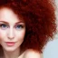 Placeholder: Woman with red curly hair and brown eyes