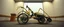 Placeholder: pinhole cam, airbrush 3d rendering, on tv screen:A five-second cinematic single take in a clean industrial presentation hall. A bizarre mechanically plausible tracked atv machine stands beside a presentation podium, designed to look like a giant mechanical praying mantis. Two large bicycle wheels form its main body and four thin articulated mechanical legs support it. Two long folded mechanical front arms resemble mantis forelegs, huge head and arms