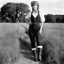 Placeholder: [photo by Helmut Newton] Grown up Pippi Longstocking: with a revealing overalls and cowboy boots in a field