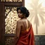 Placeholder: A divine South Asian woman stands in quiet grace, draped in a designer saree of earthy clay tones, evoking the warmth of Bengal soil. Her modern blouse features a deep back cut and minimalist straps, blending tradition with contemporary elegance. Her teary eyes shimmer with emotion, her serene face framed by soft curls and a subtle bindi. Behind her, a carved wooden door with intricate floral and geometric patterns glows in the misty golden light of Diwali. A tall palm tree looms through the fog