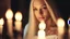 Placeholder: Closeup of a beautiful caucasian 17 year old girl with long platinum blonde hair. She is wearing a white nightgown. She is in a shadowy hallway lit by candles. Her face is well lit by candlelight. She is gazing at the viewer.