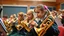 Placeholder: Young schoolgirls playing brass musical instruments, award-winning colour photograph, orchestra, school hall, beautiful lighting