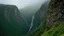 Placeholder: Mountain landscape with steep cliffs, waterfalls, lush green vegetation, and dense fog, dramatic lighting, photorealistic, high detail, 8k resolution