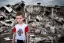 Placeholder: portrait of unkempt ukranian child war refugee wearing a t-shirt with NATO logo standing amidst rubble and ruins with mushroom cloud in the background