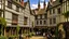 Placeholder: A Paved Courtyard, With Tudor Gothic Houses, Tall twisted Chimneys, warped Rooves, People, Shops,