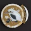 Placeholder: coaster of kingfisher ivory brooch with black pearl inlay, opalescent marble carving, decorative design, classical ornament, highly ornate, highly intricate, highly detailed etching, marble carving, warm lighting, linen backdrop