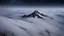 Placeholder: looking down from space at only one single sharp misty mountain cliff coming through the mist and surrounded by the mist at night starry sky. There is crucially only one mountain, do not paint more other peaks in the background.