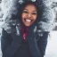 Placeholder: Image of a black woman with symetrical facial features, perfect smile, and brown coily hair in winter wonderland