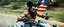 Placeholder: hi speed bad ass cyber punk masculine realistic mickey mouse rambo humanoid with hairy arms and chest, on quad, motion blurred background, holding american flag