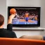 Placeholder: a man watching the New York Knicks on a very small television